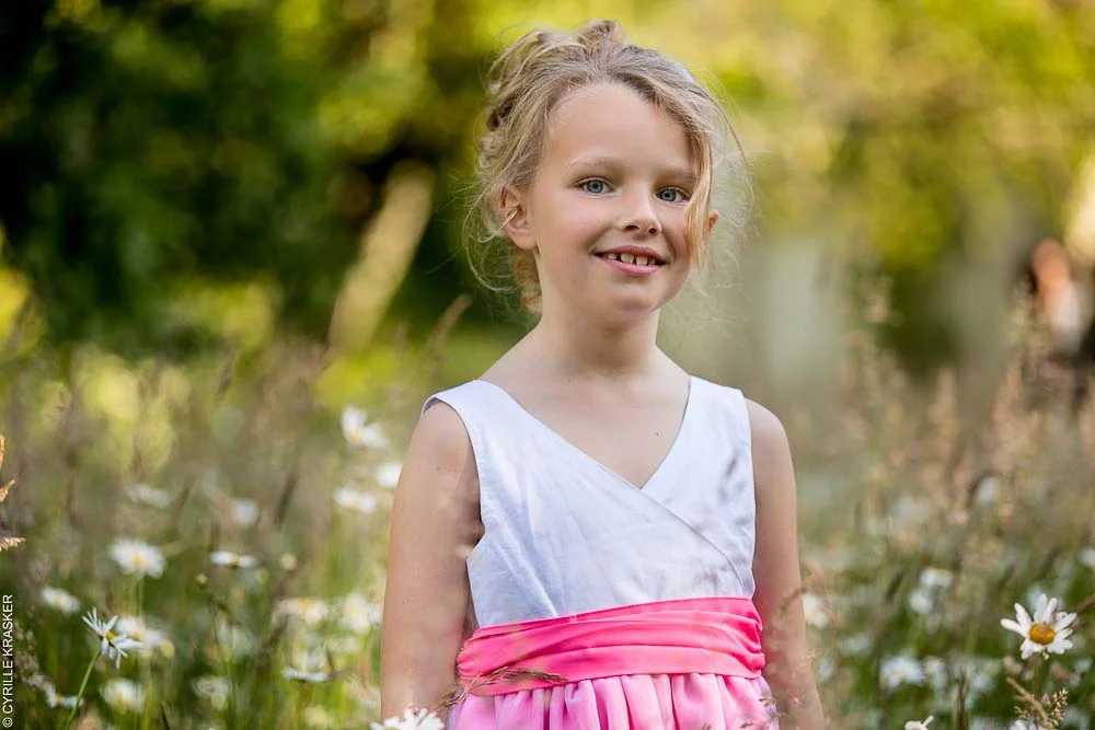 Photographe bébé à Paris : jeune fille souriante dans un champ fleuri